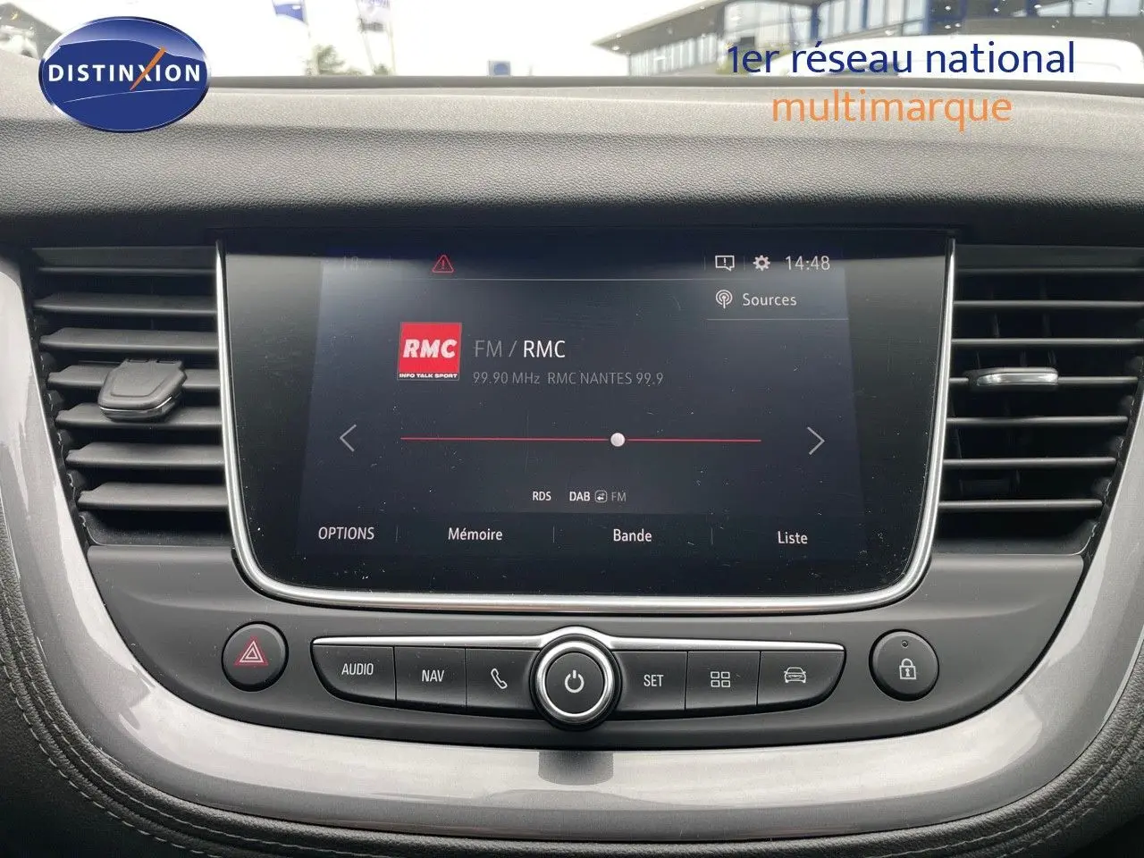 Vue rapprochée de l'écran central tactile du tableau de bord de l'Opel Grandland X avec interface radio RMC affichée.