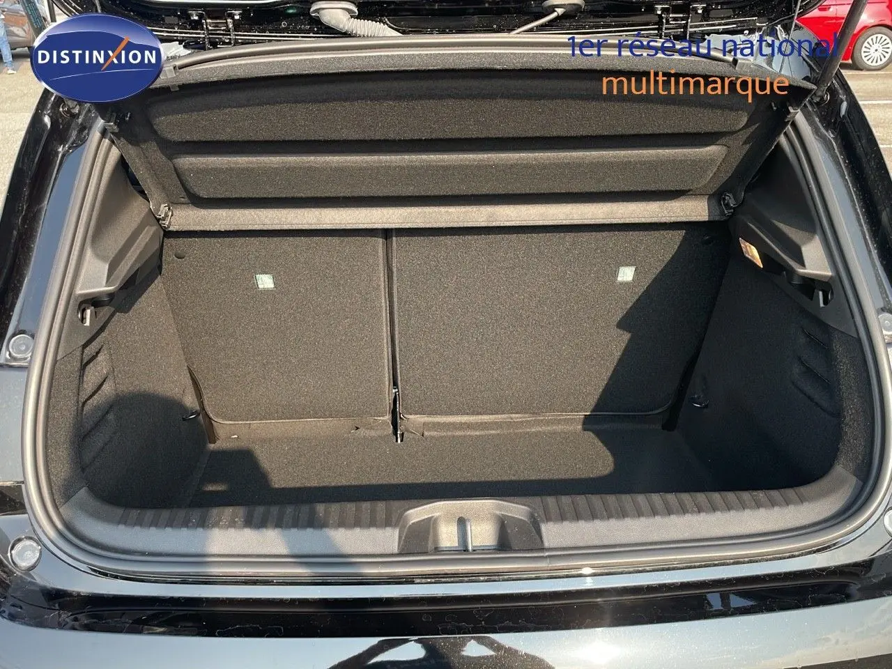 Coffre ouvert vu de l'arrière d'une Renault Clio noire étoile métal, montrant un espace de chargement propre et vide.