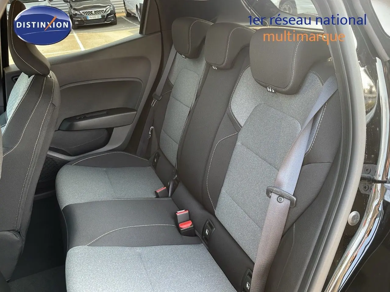 Vue intérieure sur les sièges arrière en tissu gris et noir de la Renault Clio 1.5 DCI 2025 avec porte arrière ouverte.