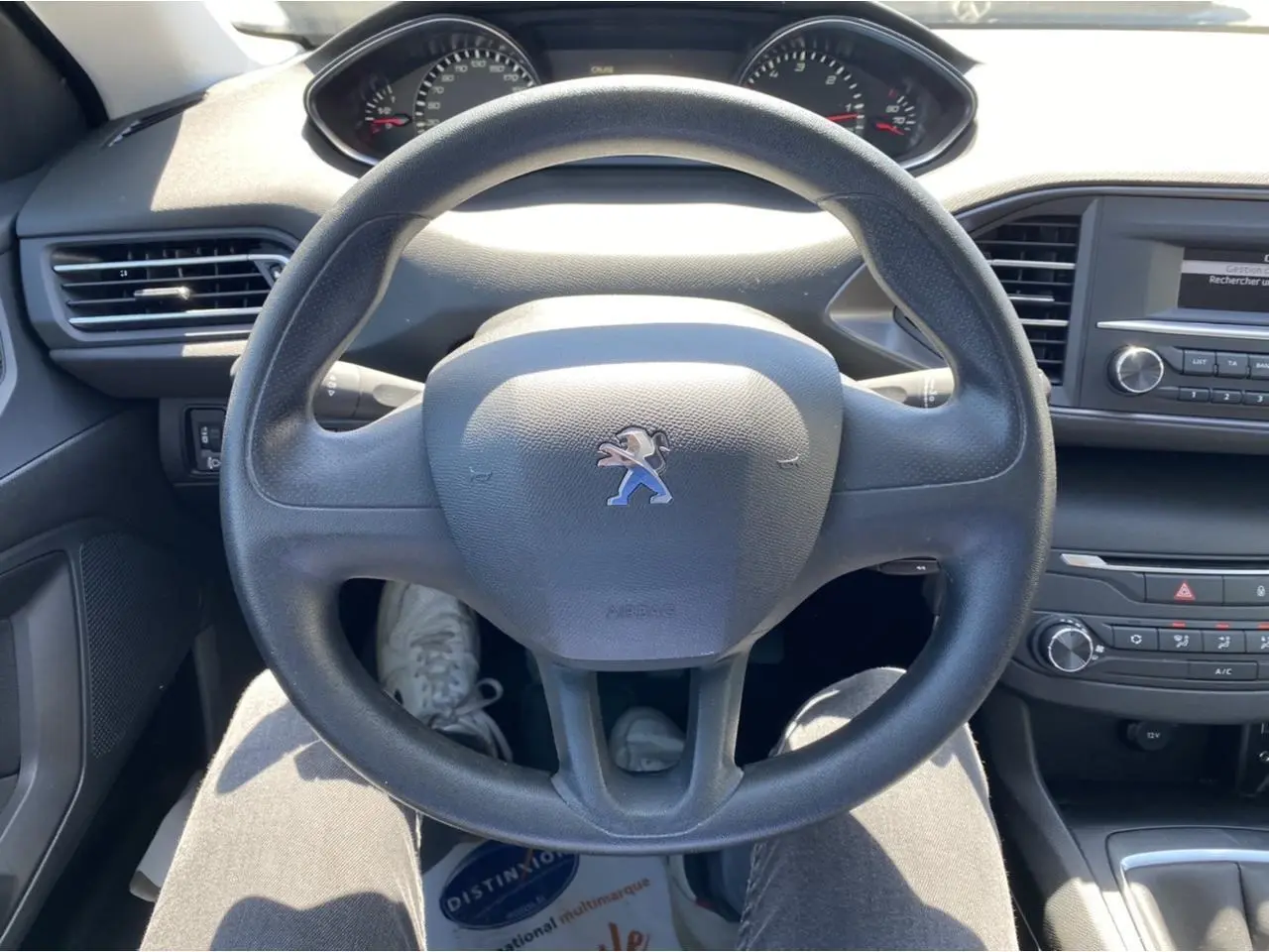 Vue intérieure centrée sur le volant noir de la Peugeot 308 SW 2017 avec tableau de bord et console centrale visibles.
