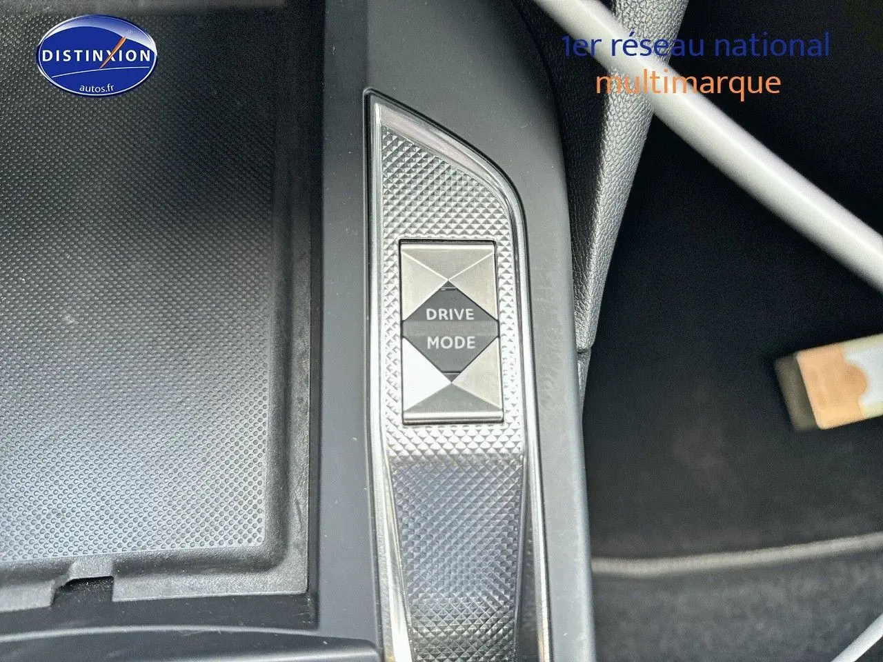 Gros plan sur le bouton Drive Mode de la console centrale du DS3 Crossback E-TENSE noir métal, intérieur moderne.