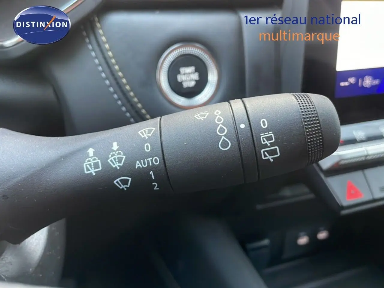 Gros plan sur la commande des essuie-glaces dans l’habitacle noir du Renault Symbioz gris, avec bouton start visible en arrière-plan.