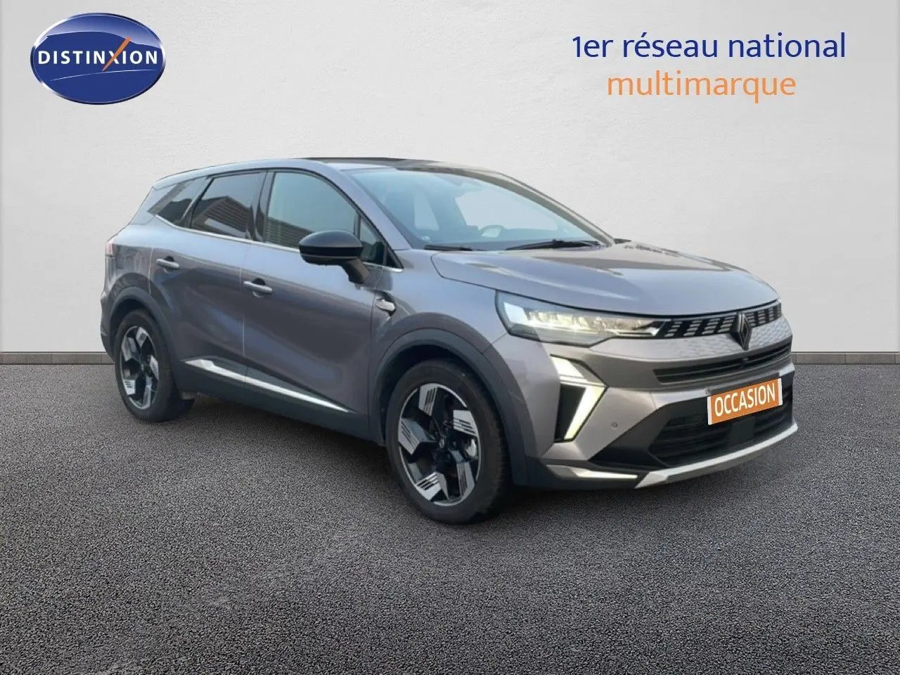 Renault Symbioz gris cassiopée métal en 3/4 avant droit, avec calandre distinctive et jantes bicolores modernes.