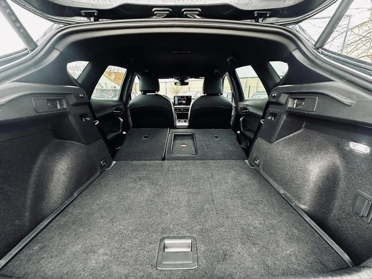 Coffre ouvert vu de l’arrière d’un CUPRA Formentor gris 2025 avec banquette arrière rabattue et intérieur noir.