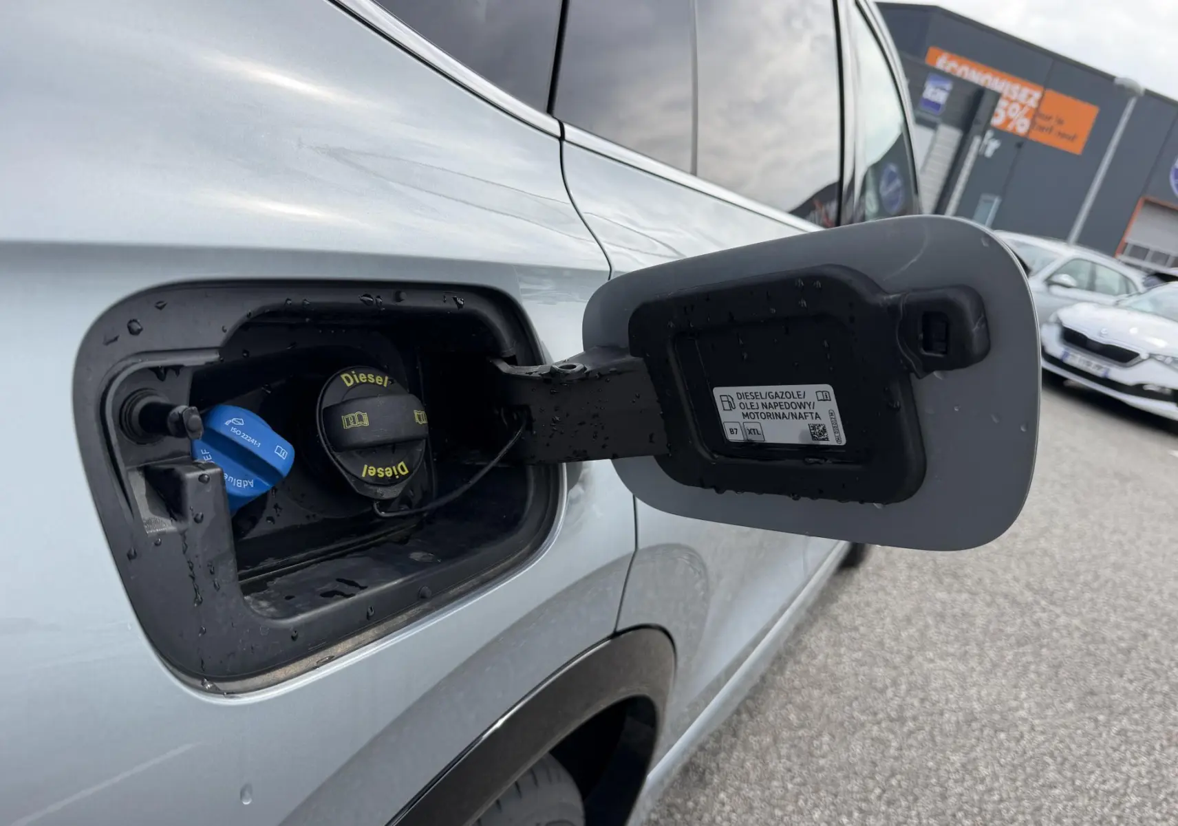 Gros plan sur la trappe à carburant gris clair du Volkswagen Tiguan 2025, avec bouchon diesel ouvert côté gauche.