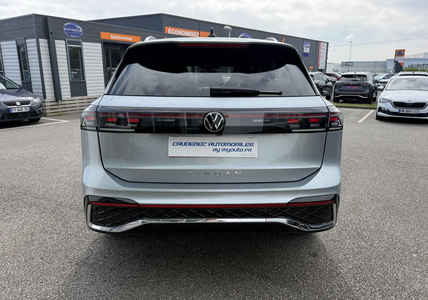 Vue arrière d'un Volkswagen Tiguan gris avec feux arrière LED 3D et logo VW centré sur un parking.