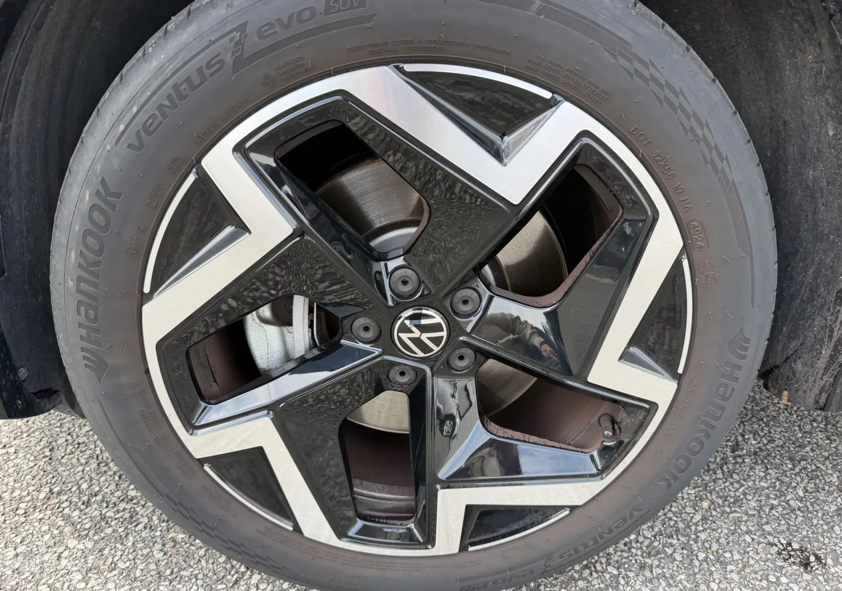 Gros plan sur la jante alliage noir et argent 19 pouces du Volkswagen Tiguan 2025 avec logo VW au centre.