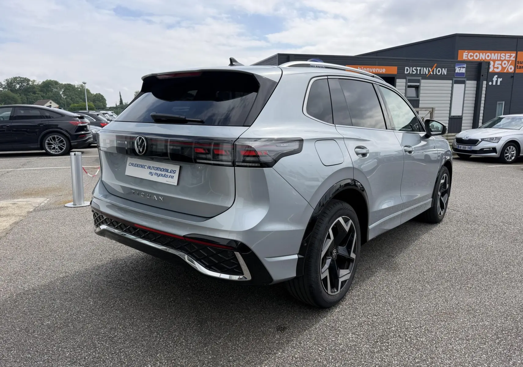 Volkswagen Tiguan gris en 3/4 arrière droit, avec feux arrière LED 3D et jantes alliage noires 19 pouces.