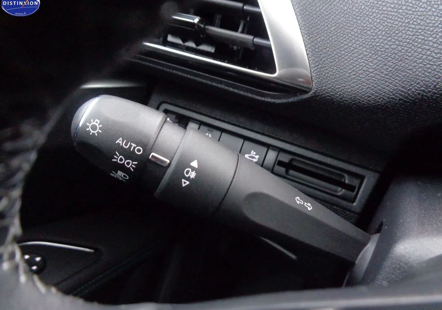 Gros plan sur la commande des phares et clignotants du Peugeot 3008 2023, intérieur noir texturé.