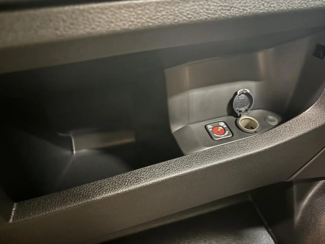 Rangement intérieur côté droit avec prise 12V et commande de désactivation airbag dans un Fiat Scudo Fourgon gris foncé.