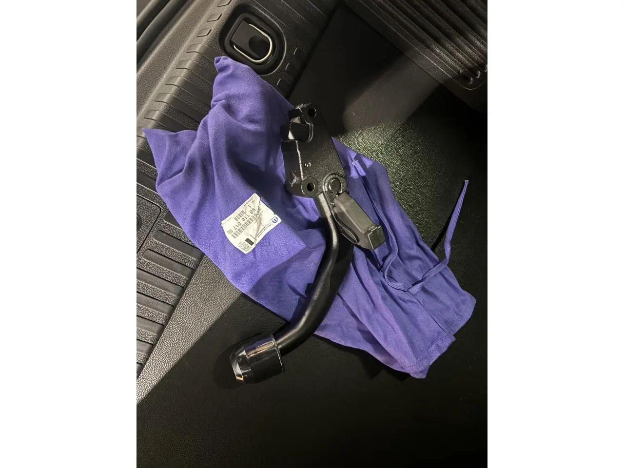 Détail de l'attelage col de cygne démontable posé sur le sol noir du coffre du FIAT Scudo Fourgon gris foncé.