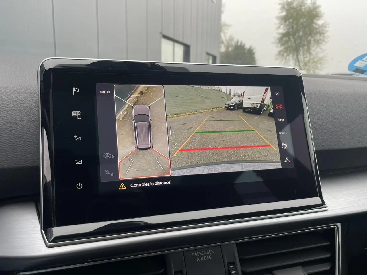 Écran tactile intérieur montrant la caméra 360° et la vue arrière du SEAT Tarraco gris Dauphin en stationnement.