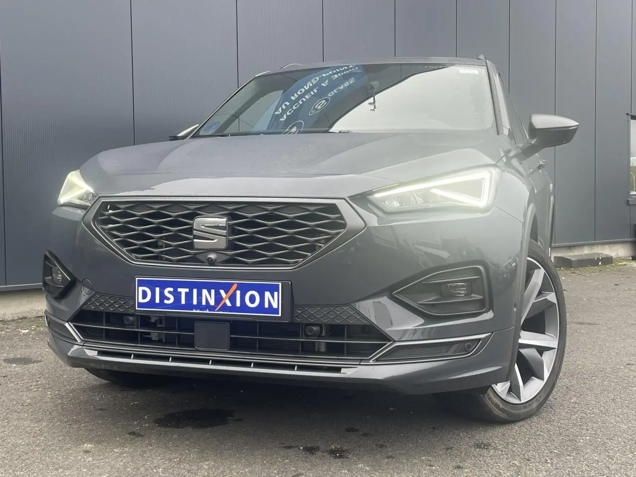 Vue avant rapprochée du SEAT Tarraco gris dauphin avec phares LED allumés et jantes alliage 20 pouces côté droit visible.