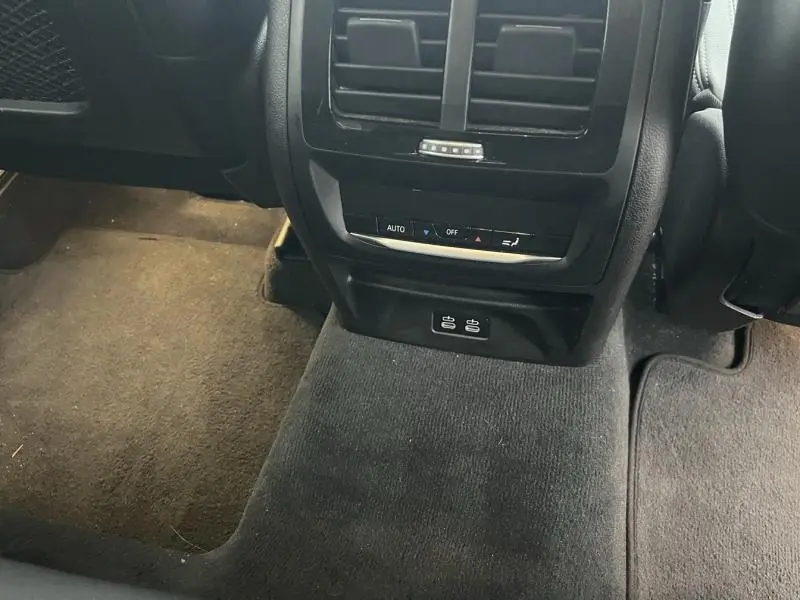 Vue rapprochée de la console arrière noire avec commandes de climatisation et ports USB du BMW X3 xDrive30eA 2020.