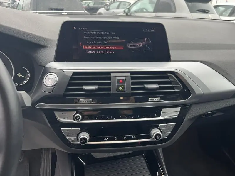 Tableau de bord et console centrale du BMW X3 xDrive30e 2020, affichage écran tactile avec réglages de charge visibles.