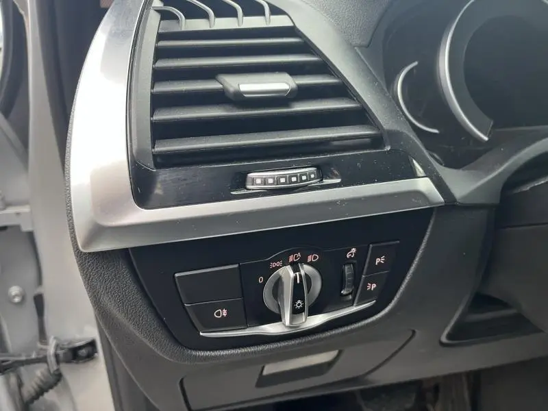 Détail du tableau de bord côté gauche d'une BMW X3 glaciersilber 2020, avec commandes d'éclairage et ventilation.