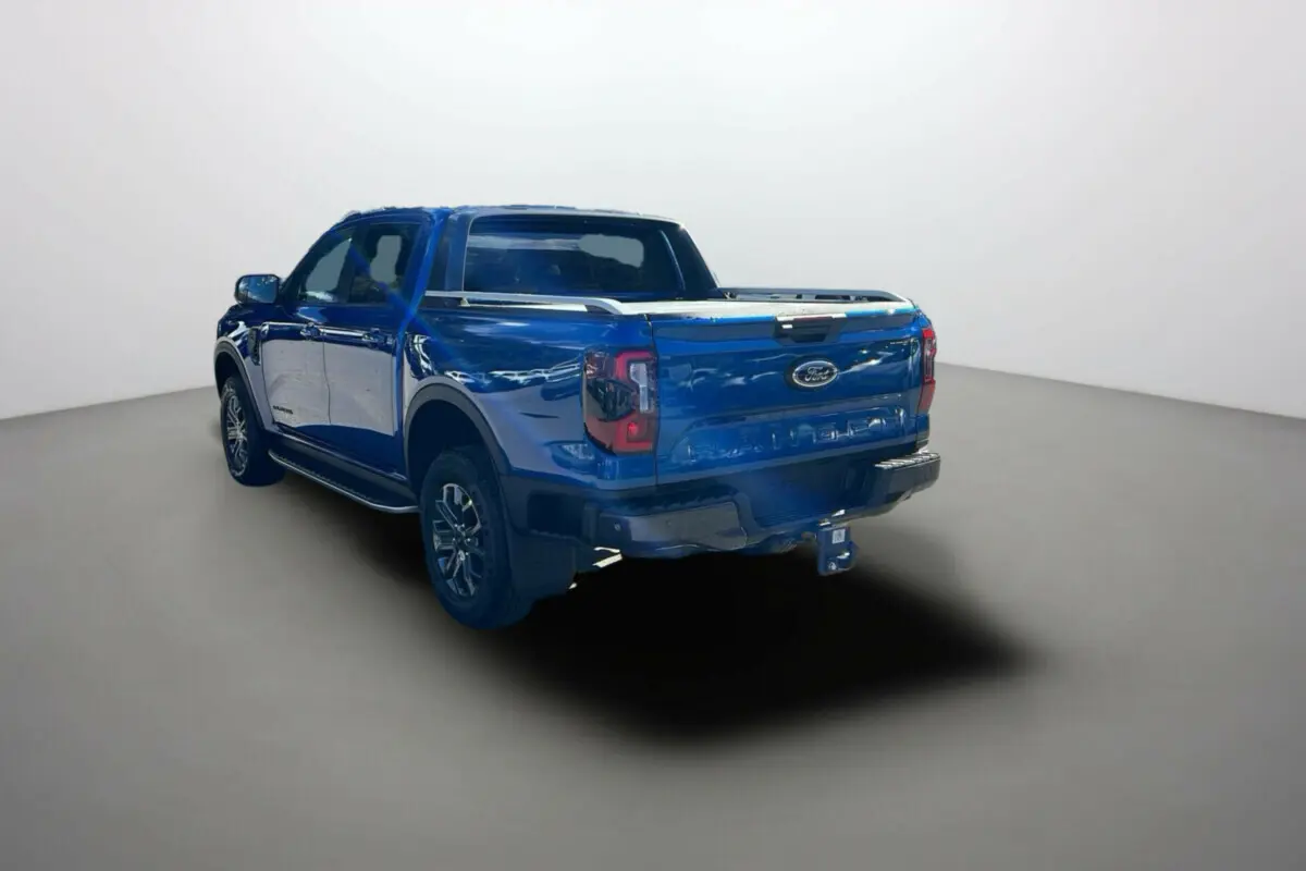 Ford Ranger 2025 bleu lightning vu en 3/4 arrière droit avec benne et attelage visibles