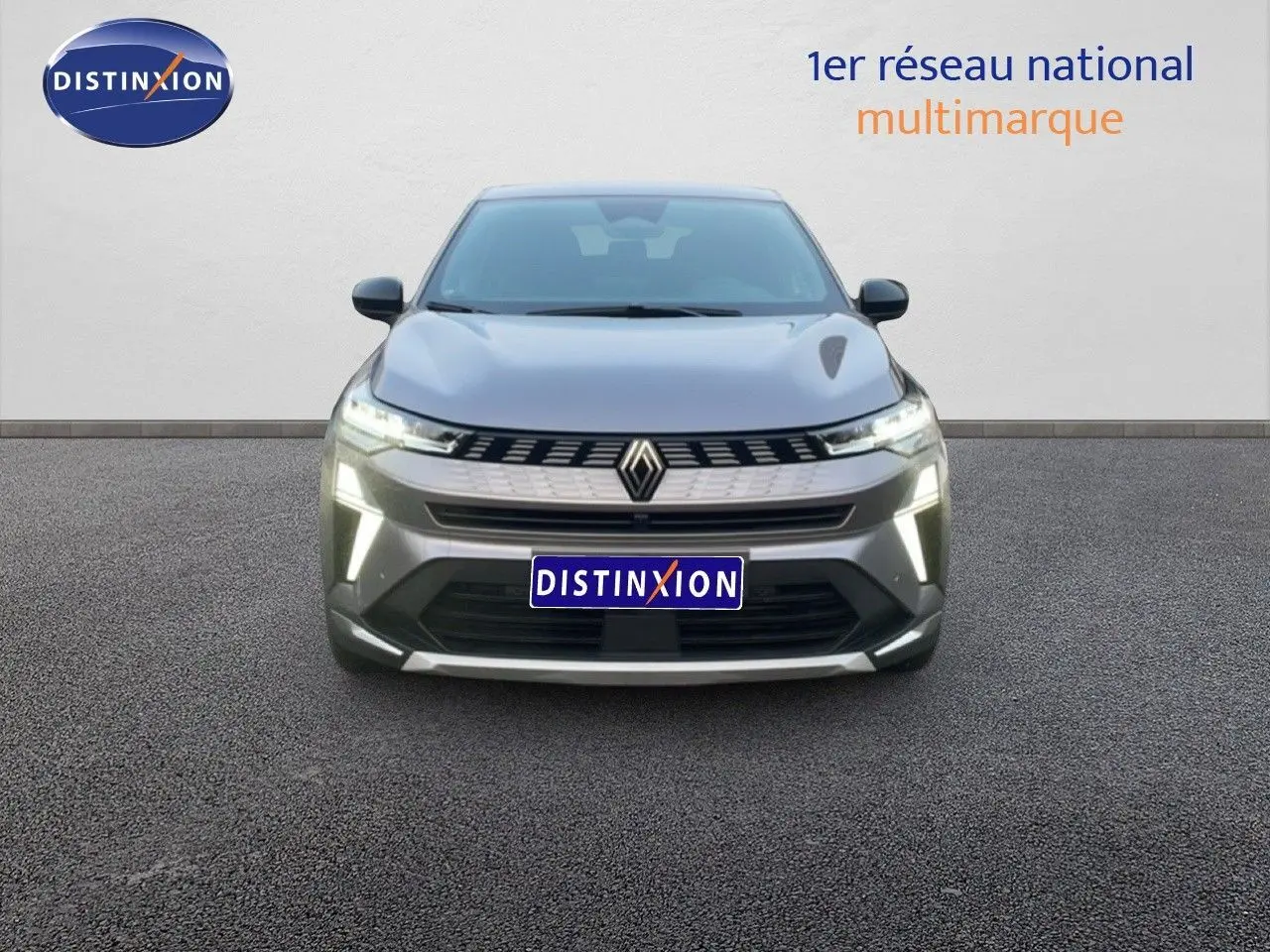 Vue frontale du Renault Symbioz gris cassiopée métal avec feux LED allumés sur fond neutre.