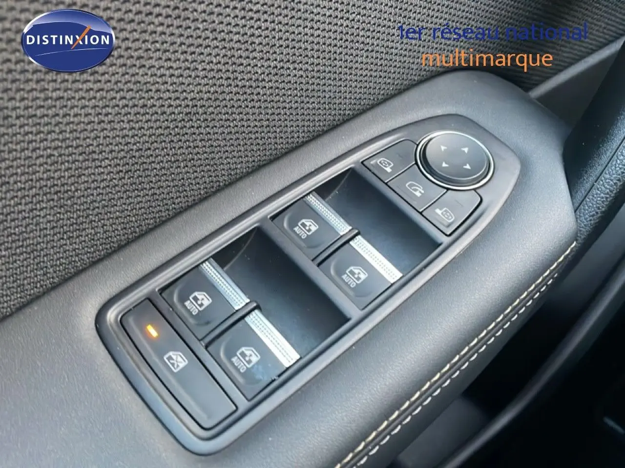 Gros plan sur les commandes de lève-vitres et réglages des rétroviseurs côté conducteur d’un Renault Symbioz gris cassiopée.