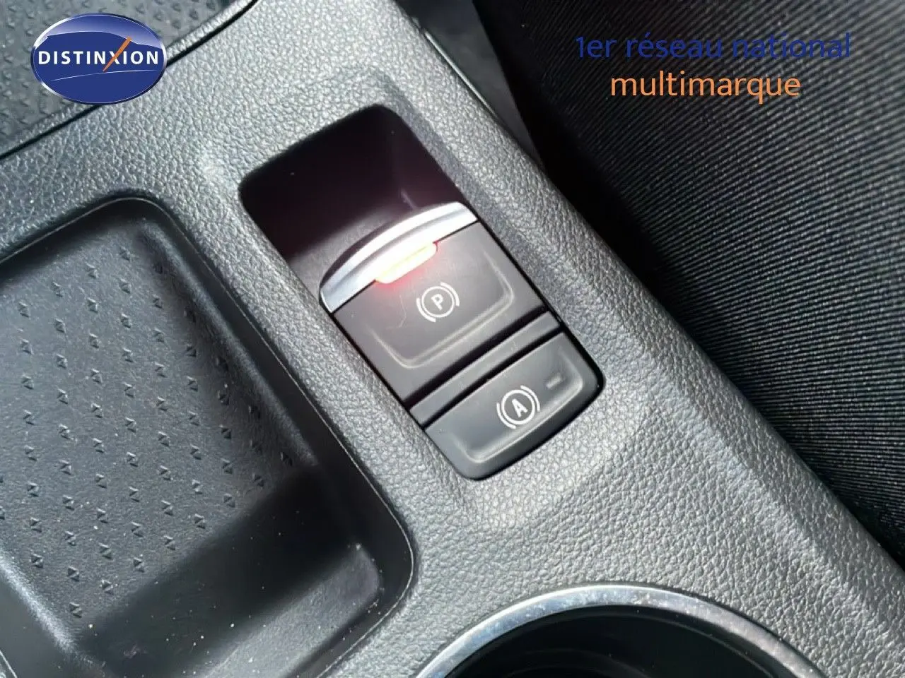 Gros plan sur la console centrale de la Renault Symbioz gris cassiopée, mettant en valeur les boutons de frein à main et auto hold.