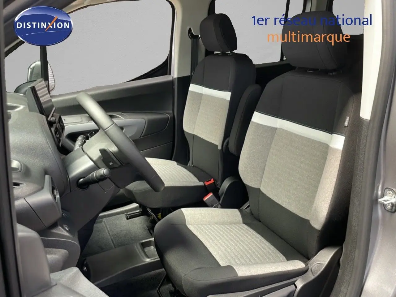 Vue intérieure côté conducteur du Citroën Berlingo gris Artense, sièges tissu bicolore gris et noir avec volant multifonction.