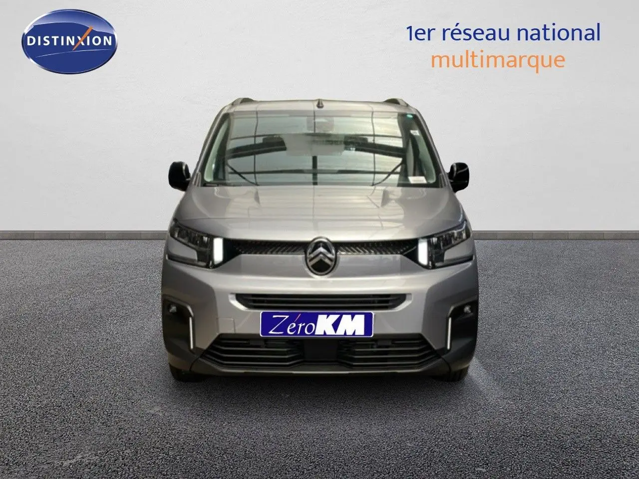 Vue frontale d'un Citroën Berlingo gris Artense métal 2026 avec calandre moderne et feux LED allumés.