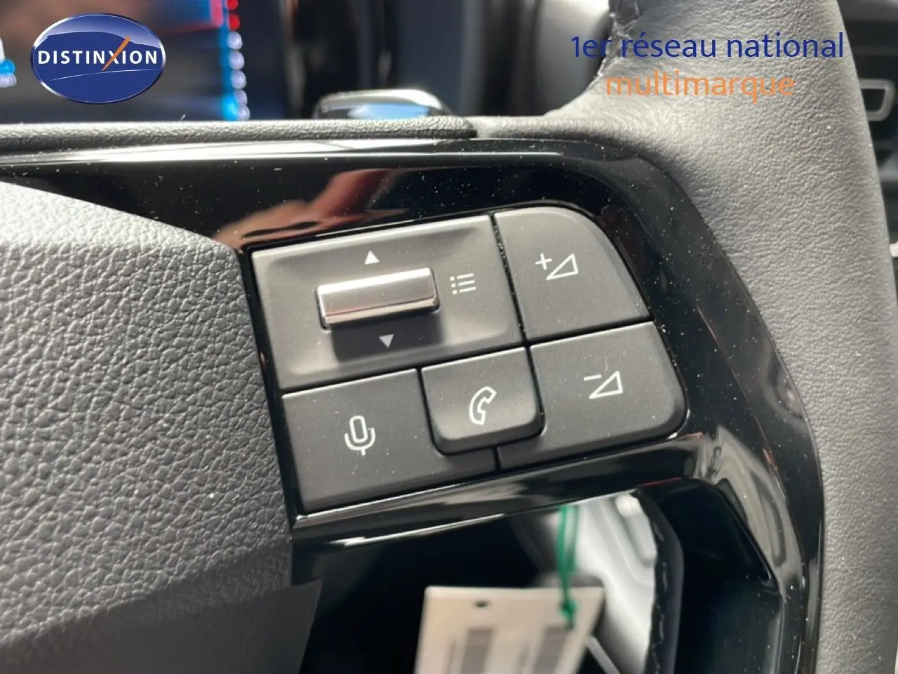 Gros plan sur les commandes multifonctions noires du volant du Citroën Berlingo gris Artense, version 2026.