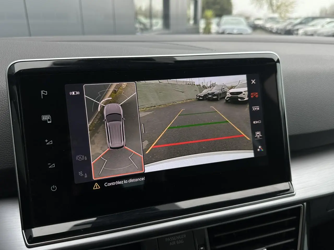 Écran tactile intérieur montrant la caméra 360° et vue arrière du SEAT Tarraco blanc Oryx en stationnement.