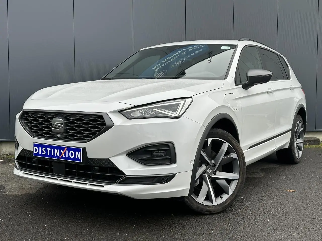 SEAT Tarraco blanc Oryx en 3/4 avant droit, avec jantes alliage 20 pouces et toit ouvrant panoramique visible.