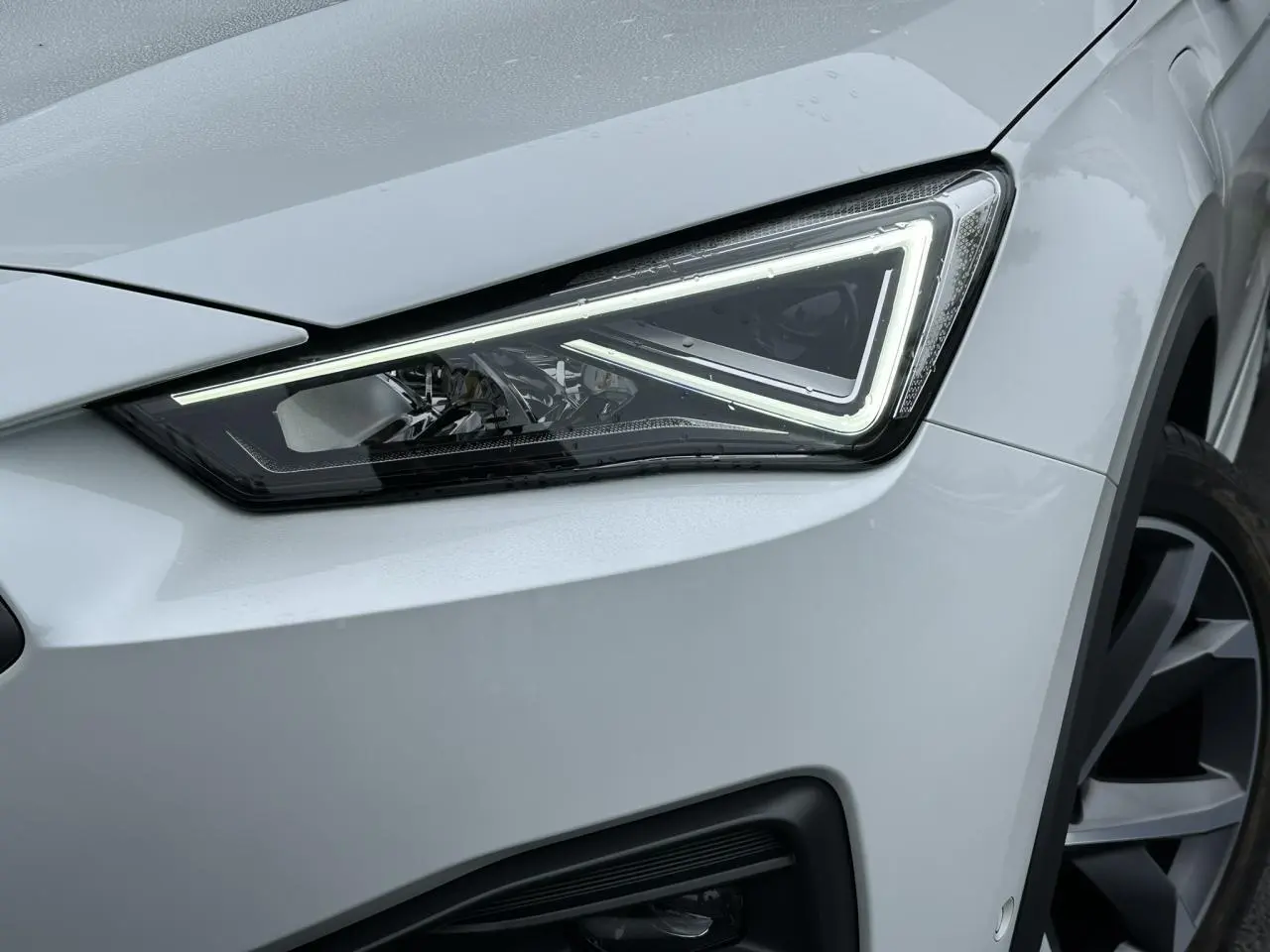 Gros plan sur le phare avant droit blanc Oryx du SEAT Tarraco 1.4 e-Hybrid 2024 avec jante alliage 20 pouces.
