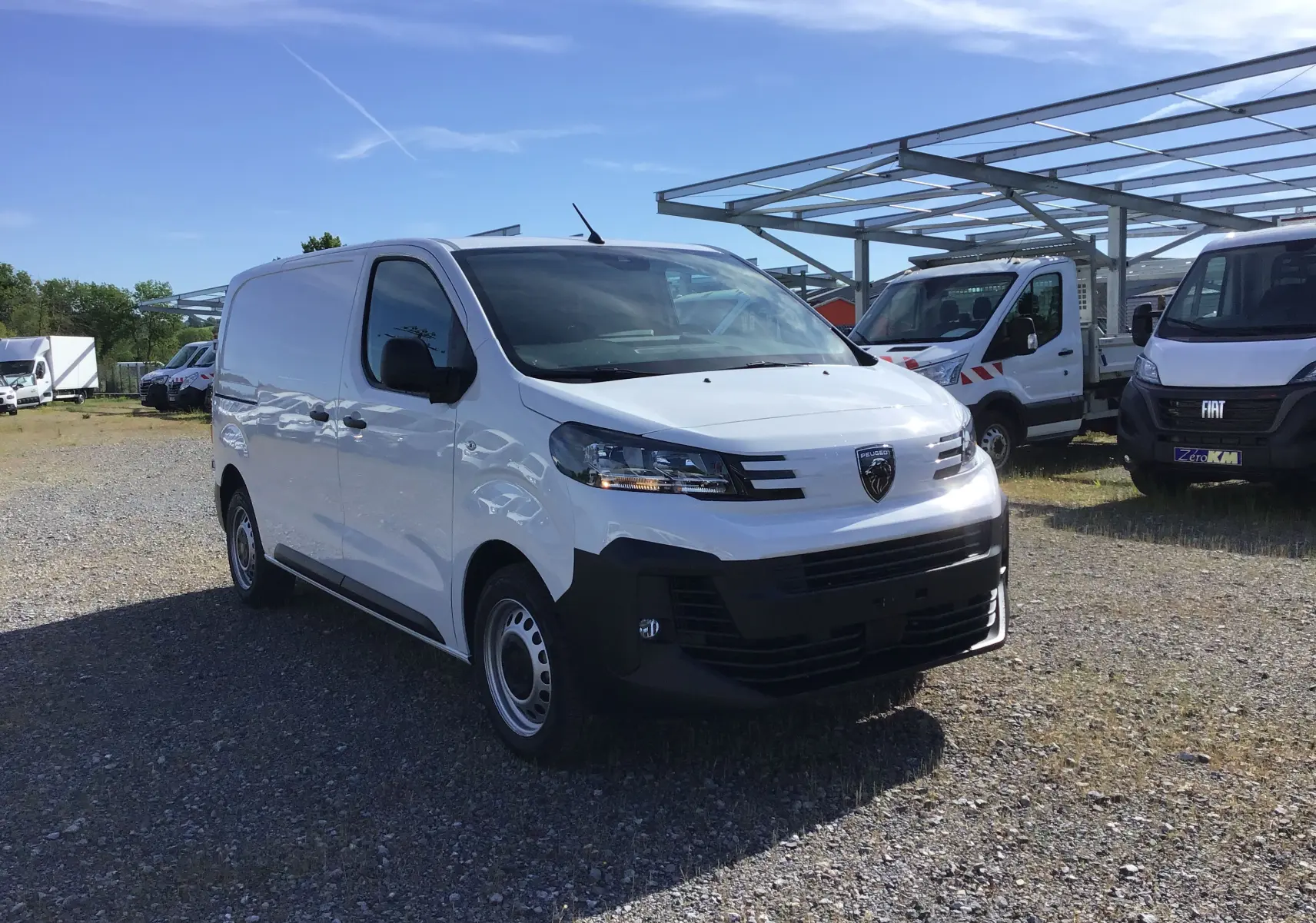 Fourgon blanc Peugeot Expert vu en 3/4 avant droit, avec calandre noire et jantes acier simples.