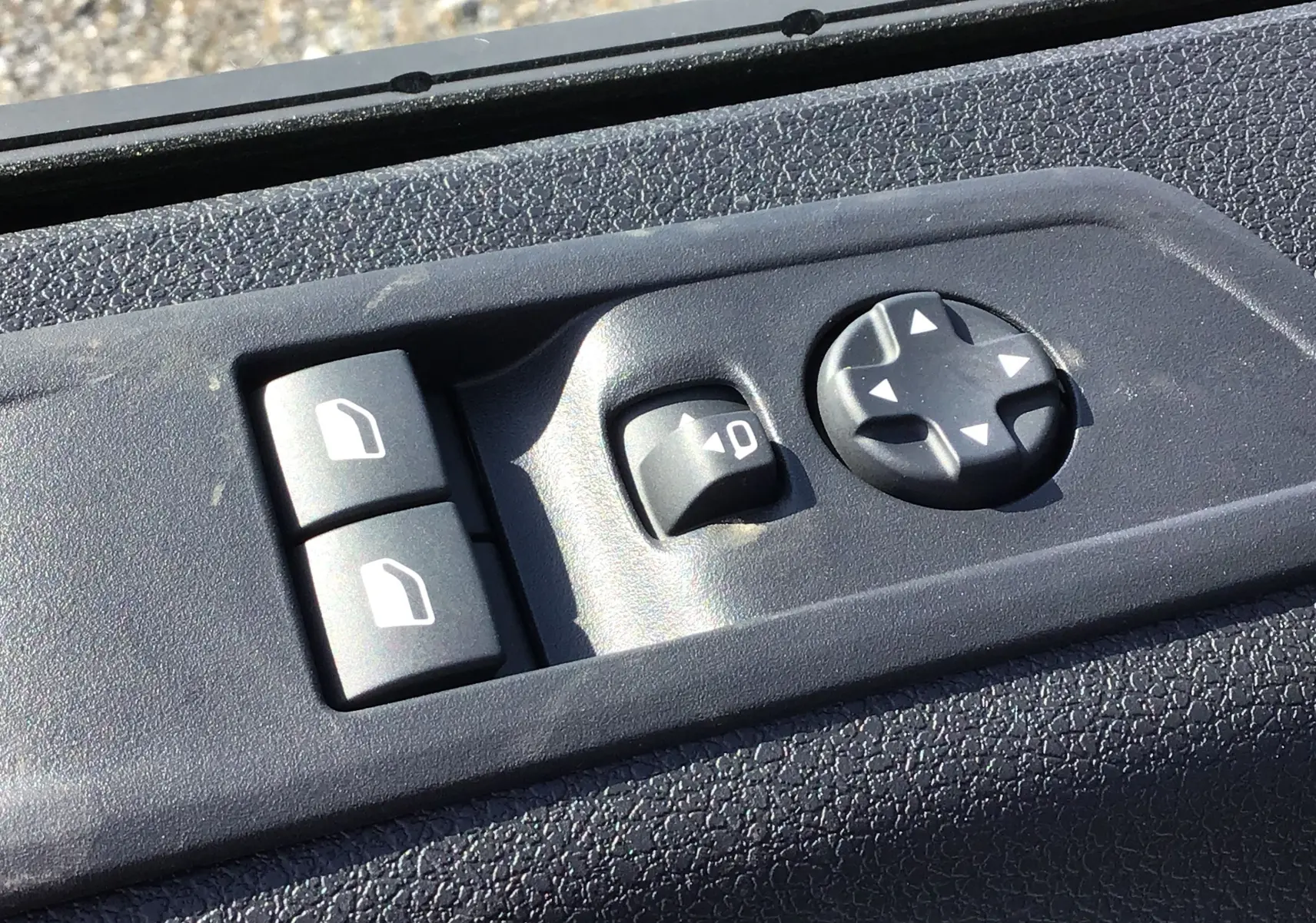 Gros plan sur les commandes de réglage des rétroviseurs et vitres du côté conducteur du Peugeot Expert Fourgon blanc 2025.