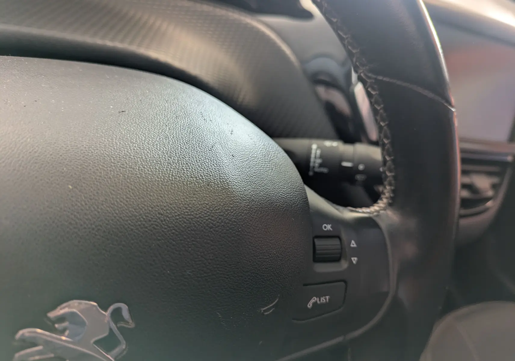 Gros plan sur le volant noir de la Peugeot 208 Allure 2019, avec commandes intégrées visibles à droite.