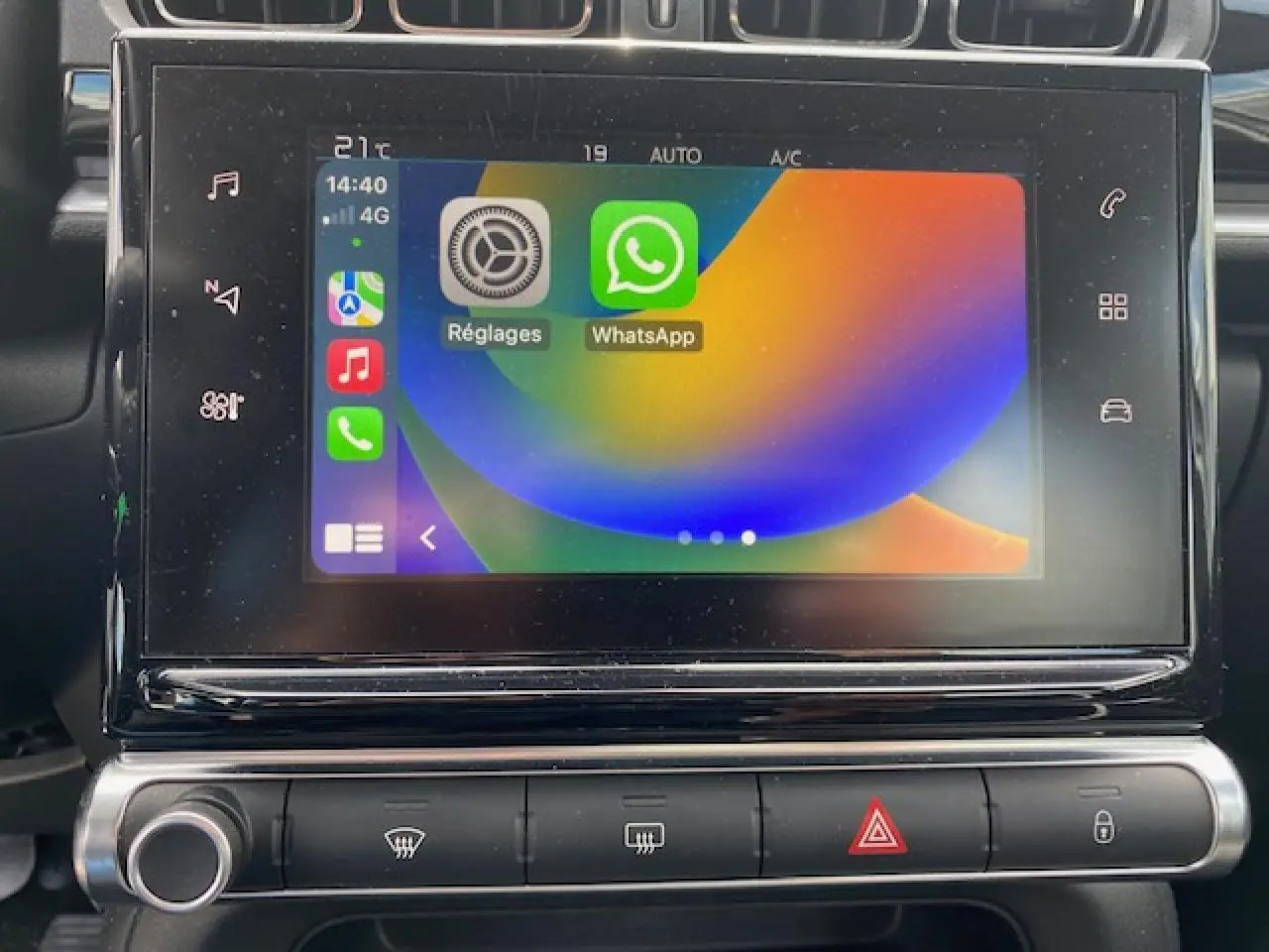 Écran tactile central de la Citroën C3 2017 affichant Apple CarPlay avec applications Réglages et WhatsApp, vue frontale rapprochée.