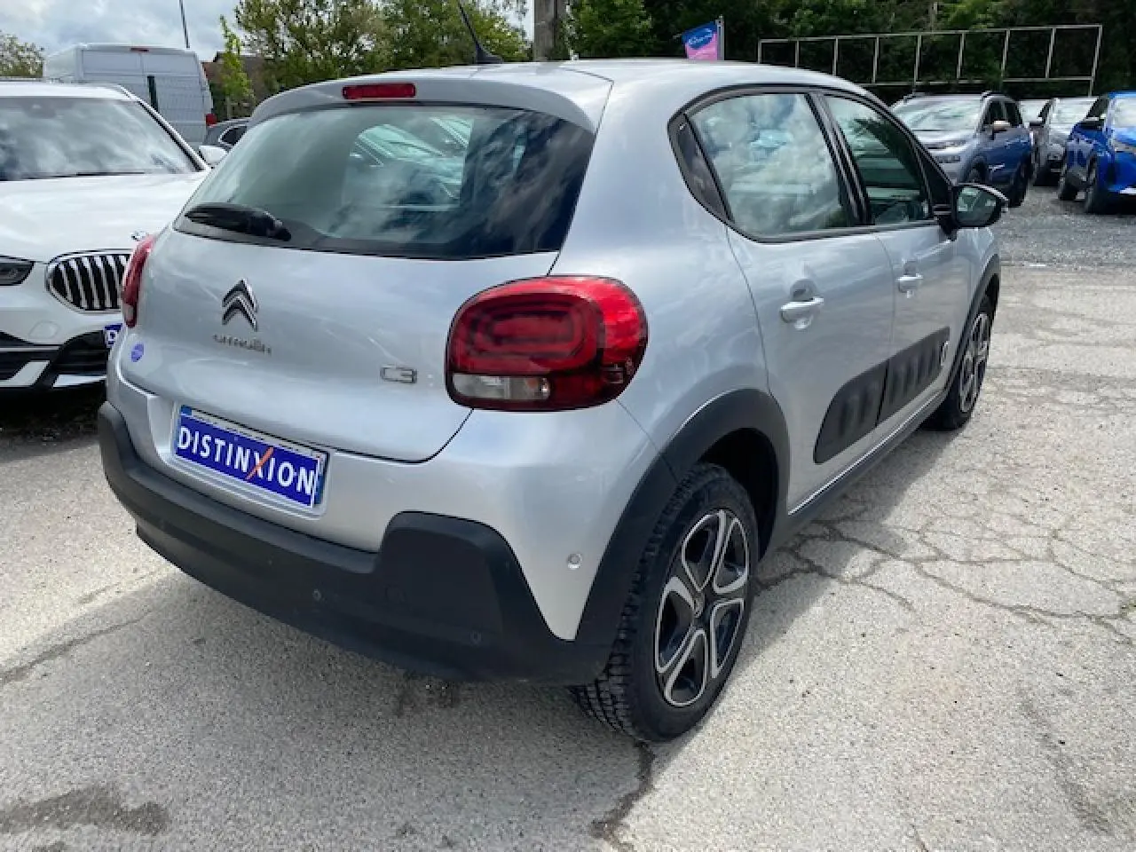 Vue 3/4 arrière droite d'une Citroën C3 gris clair avec protections latérales noires et jantes 16 pouces.