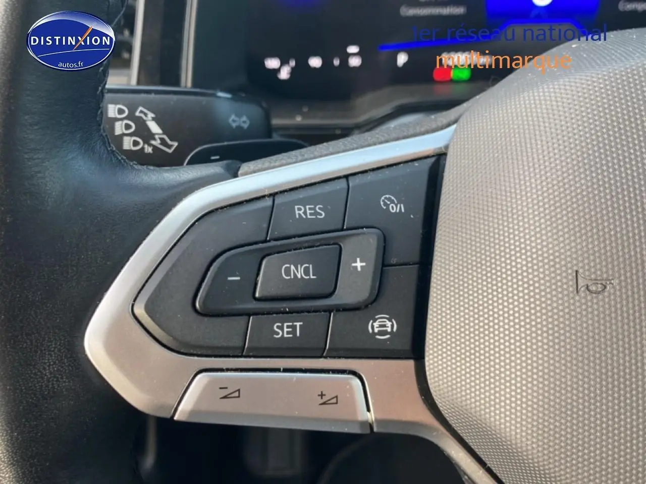 Gros plan sur les commandes au volant côté gauche du Volkswagen Polo gris cendre 2025 avec boutons de régulateur de vitesse.