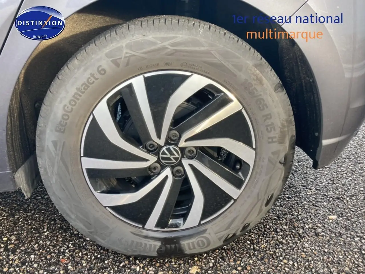 Gros plan sur la jante alliage 15 pouces noire et argentée du côté avant droit d'une Volkswagen Polo gris cendre.