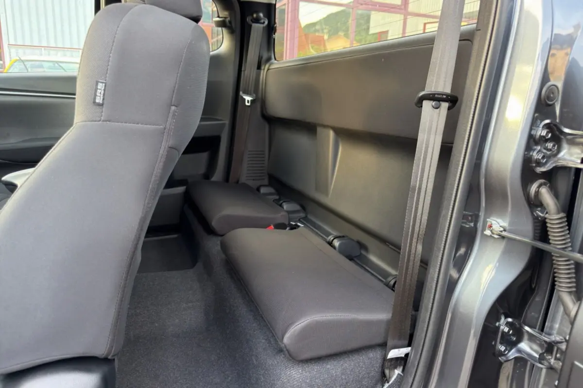 Vue intérieure côté droit sur les sièges arrière strapontins en tissu du pick-up Isuzu D-MAX gris Obsidian 2026.