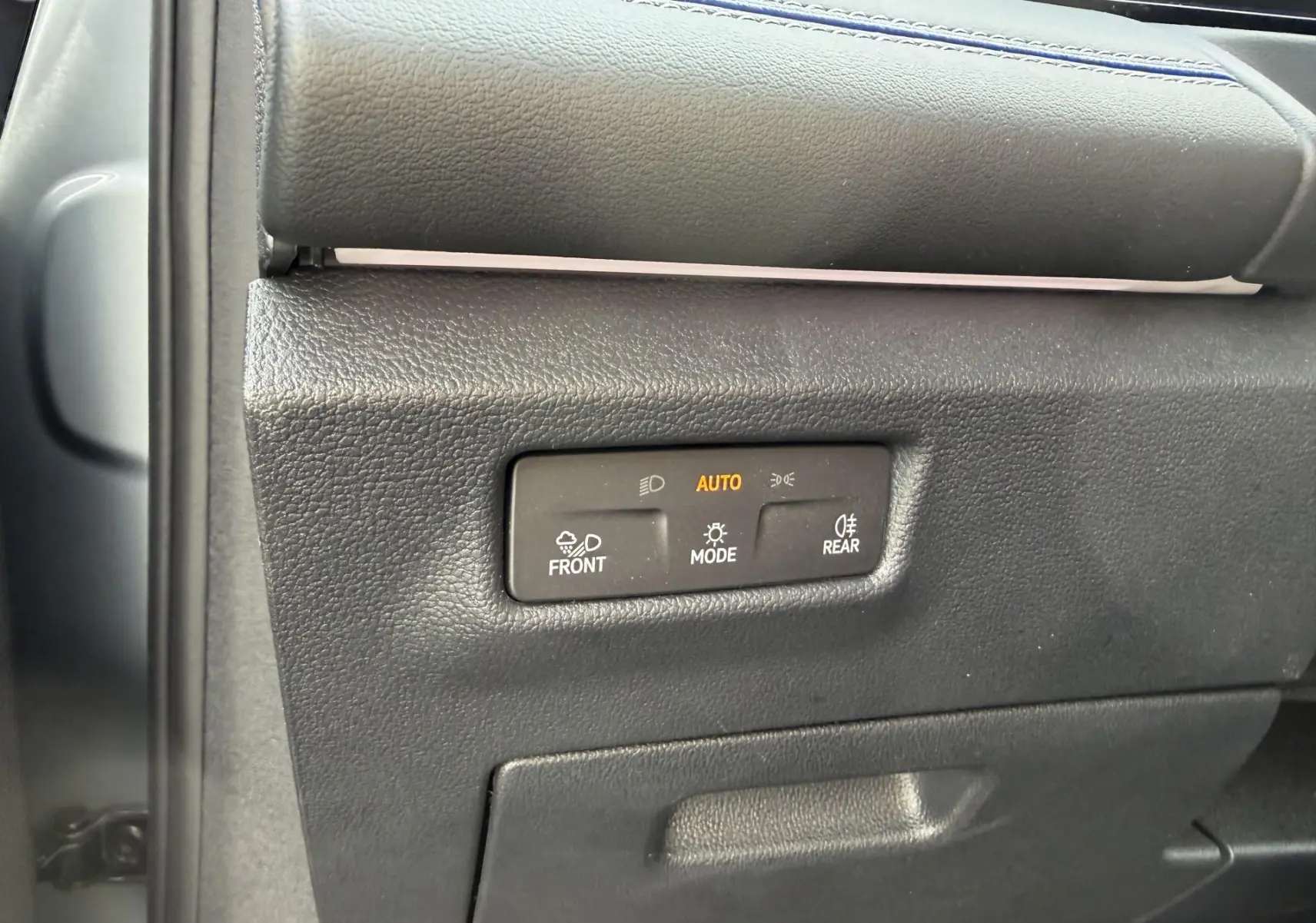 Détail du panneau de commandes d'éclairage intérieur noir du Volkswagen Tiguan 2025, avec mode automatique activé.