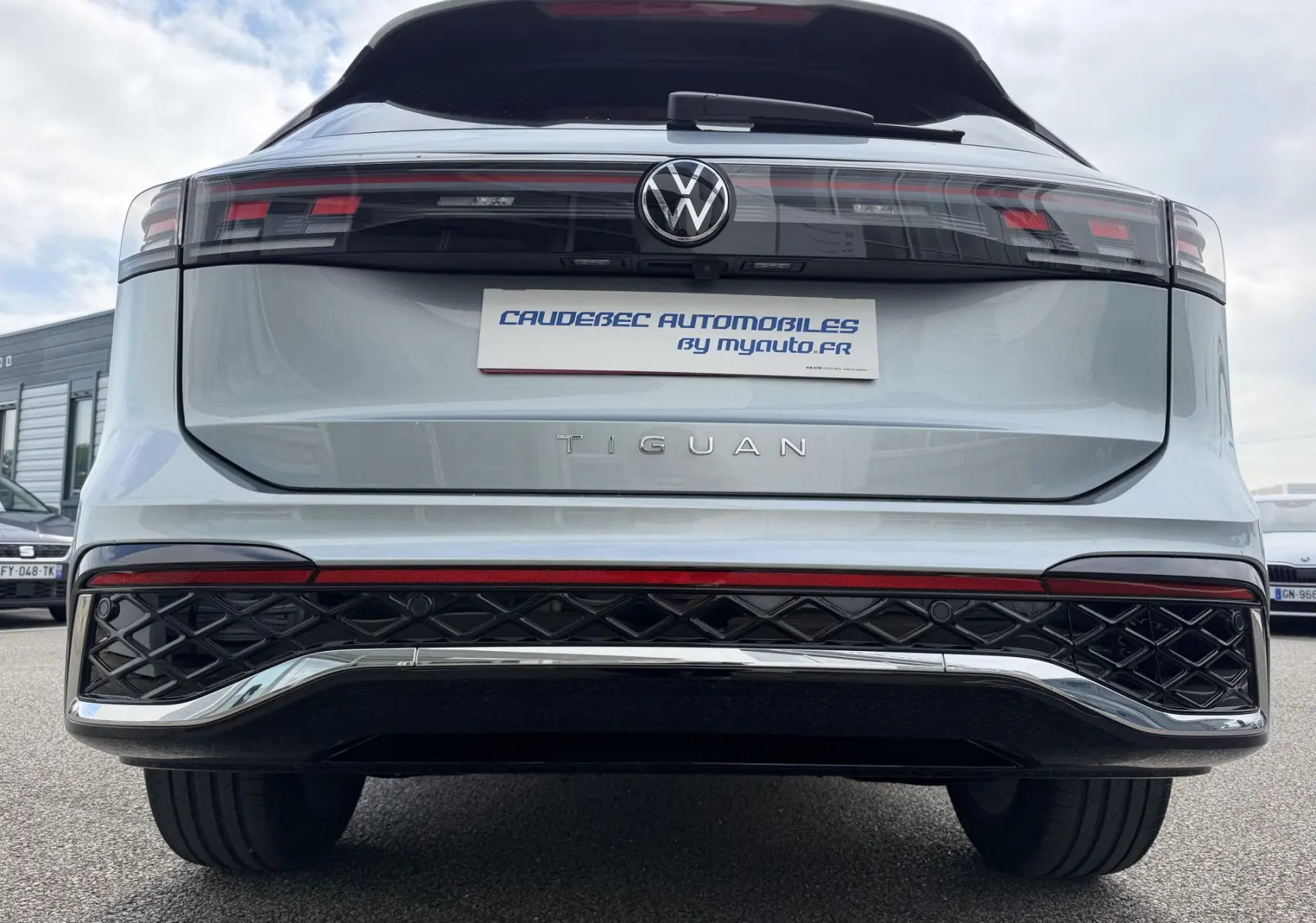 Vue arrière d'un Volkswagen Tiguan gris 2025 avec feux arrière LED 3D et logo VW central sur hayon.