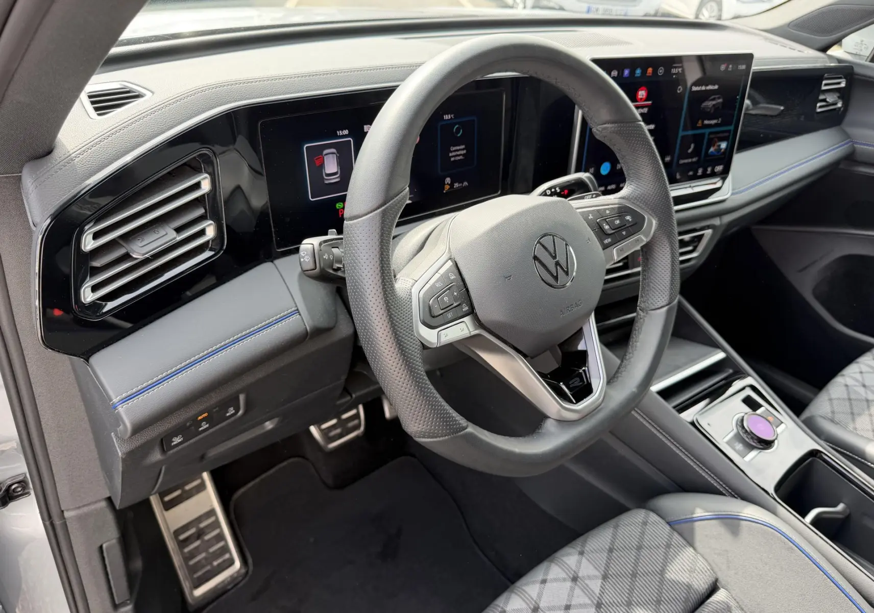 Vue intérieure côté conducteur du Volkswagen Tiguan 2025, volant multifonction cuir et tableau de bord digital.