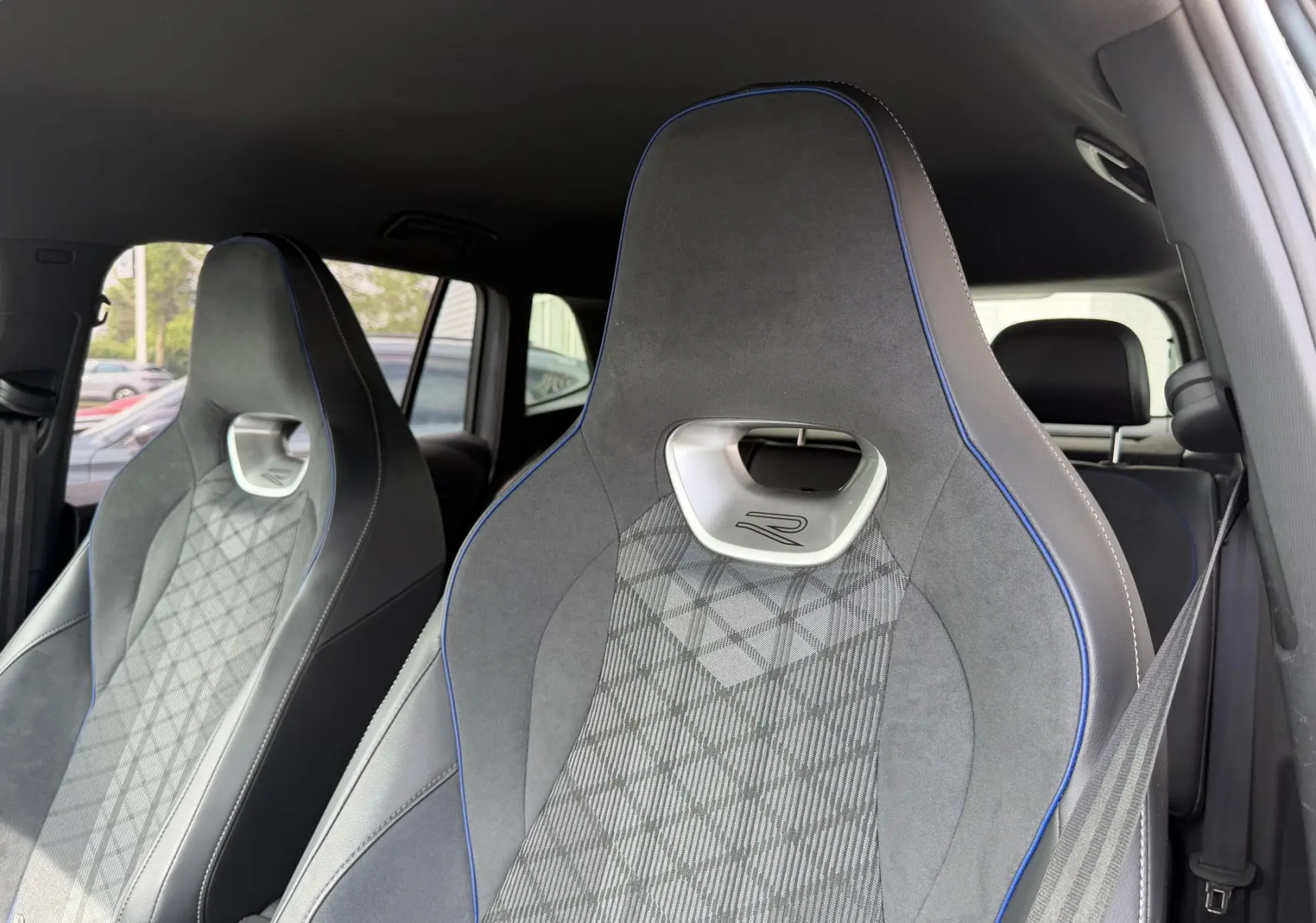 Gros plan sur les sièges avant sport gris avec surpiqûres bleues et logo R du Volkswagen Tiguan 2025.