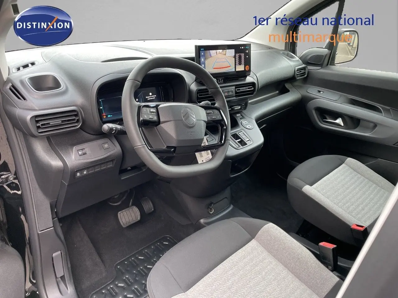 Vue intérieure côté conducteur du Citroën Berlingo 2026 noir, avec tableau de bord moderne et écran tactile affichant la caméra de recul.