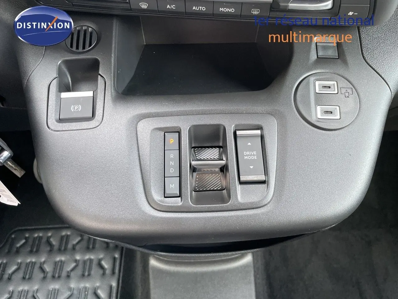 Gros plan sur la console centrale noire du Citroën Berlingo 2026, avec commandes de boîte auto et ports USB visibles.
