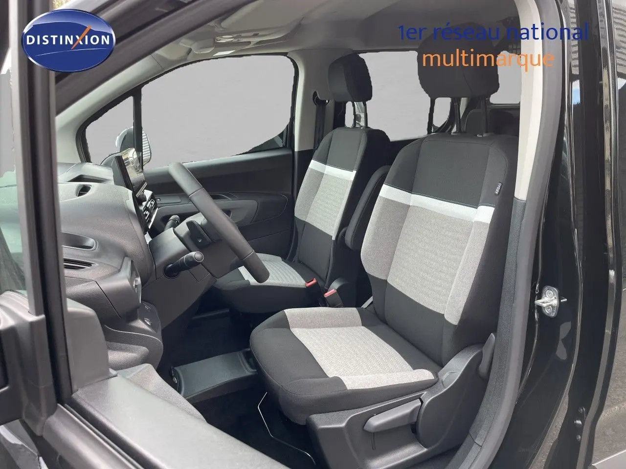Vue intérieure côté gauche du Citroën Berlingo noir Perla Nera, montrant les sièges avant en tissu bicolore gris et noir.