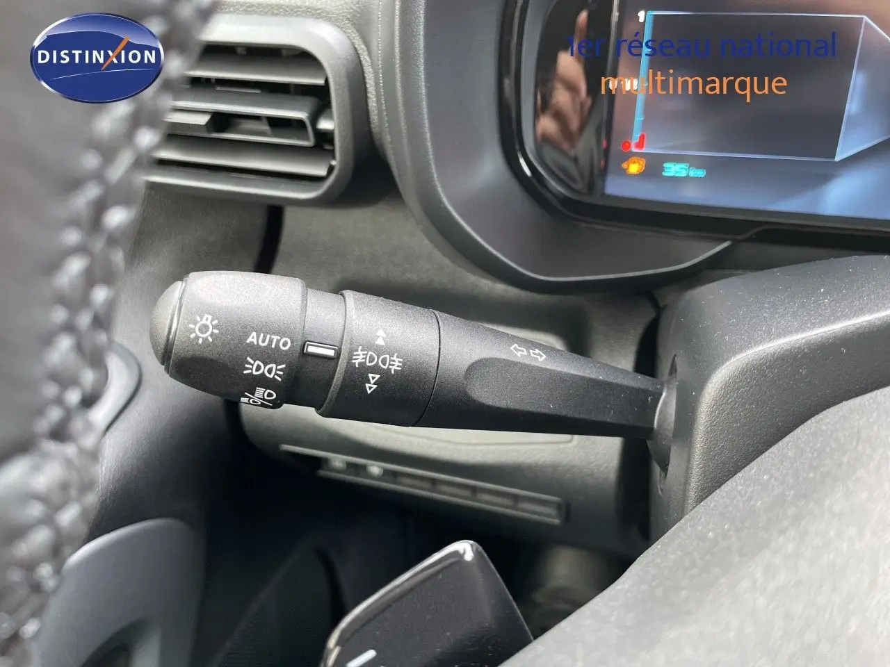 Gros plan sur la manette de clignotants à gauche du volant dans l'habitacle du Citroën Berlingo noir Perla Nera 2026.