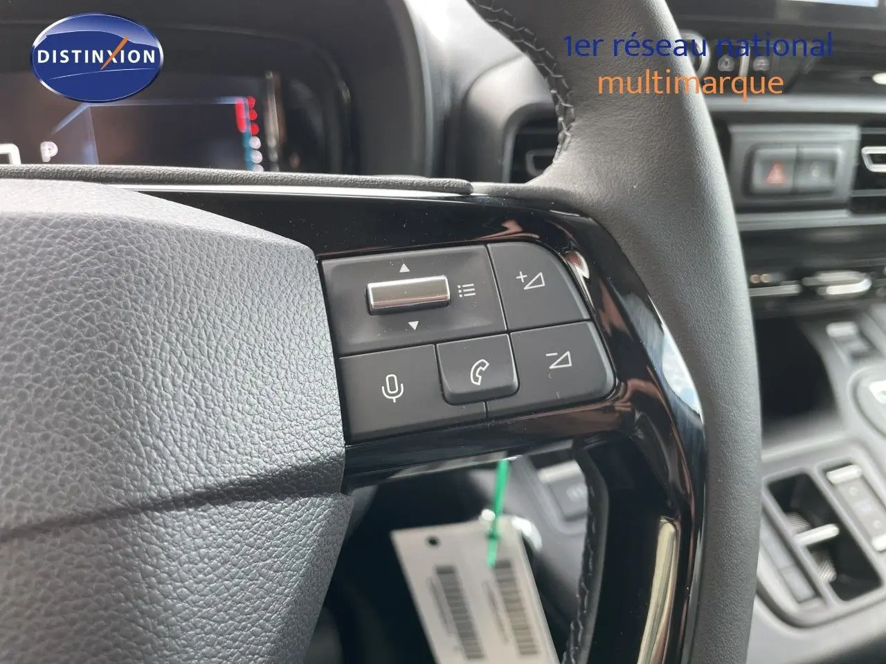 Gros plan sur les commandes au volant du Citroën Berlingo 2026, finition noire avec boutons multifonctions et tableau de bord en arrière-plan.