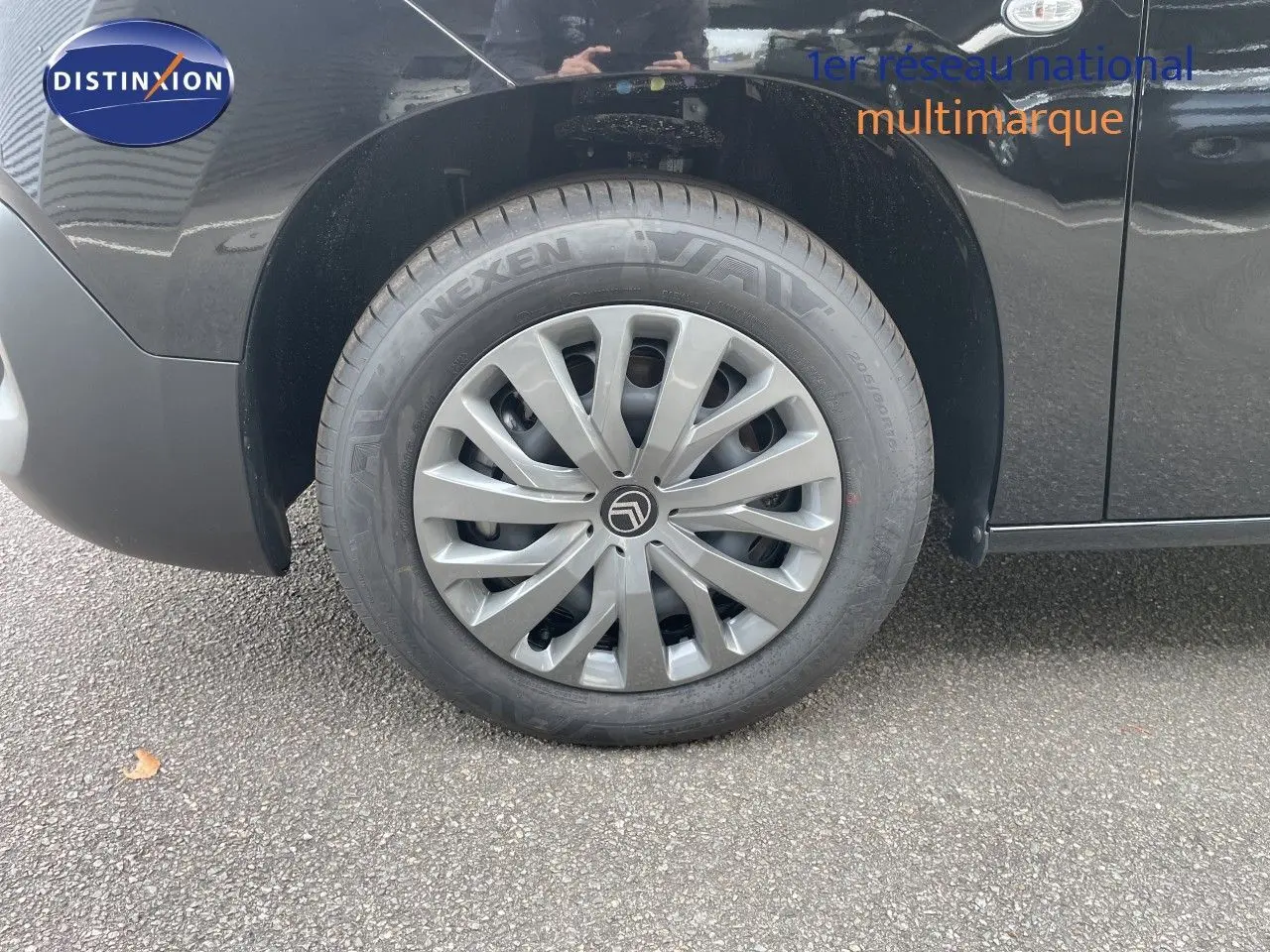 Gros plan sur la roue avant gauche noire d’un Citroën Berlingo 2026 avec enjoliveur gris et logo Citroën central.