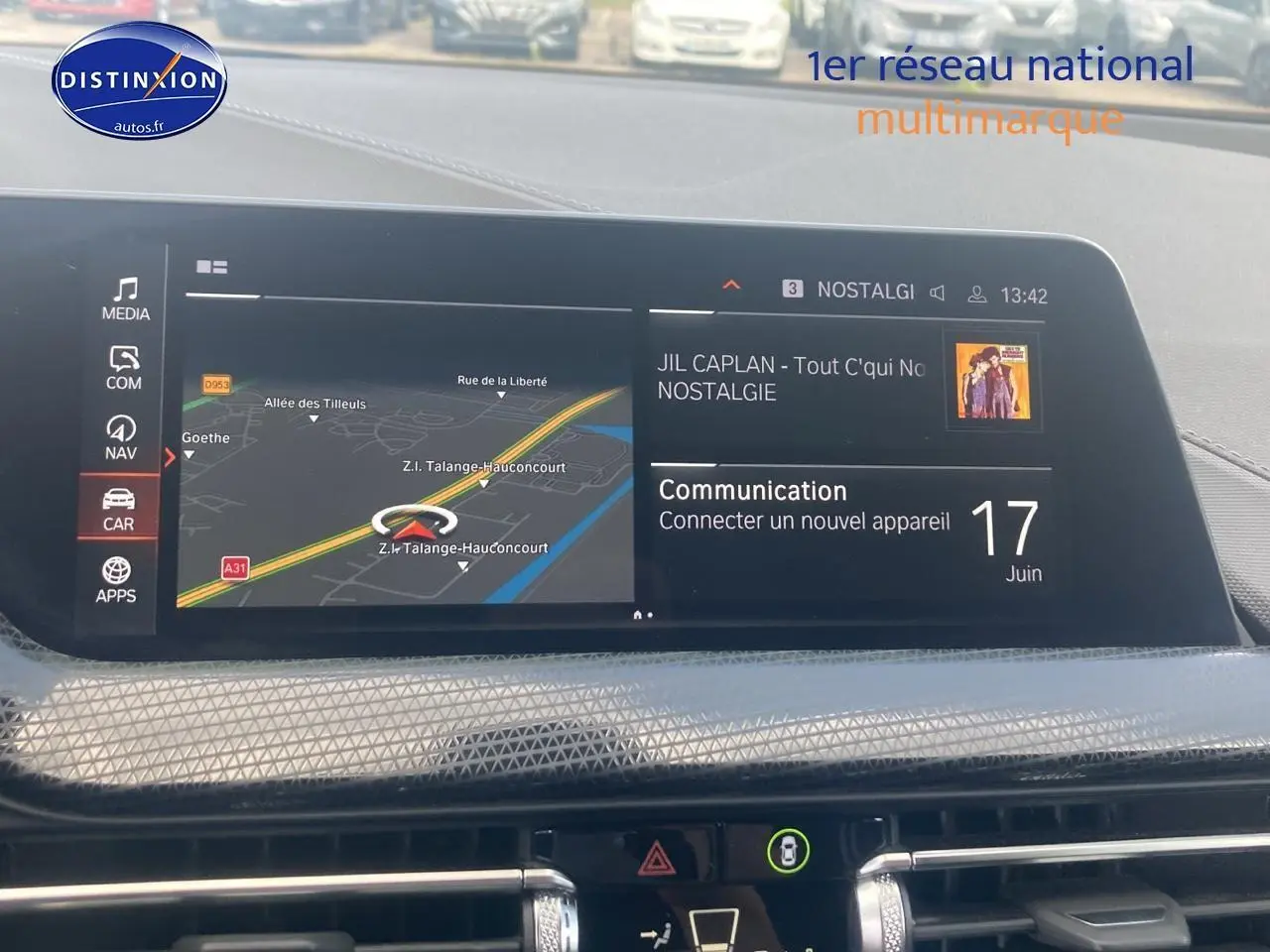 Écran central du BMW Série 1 118i 2023 affichant navigation et musique, intérieur noir moderne avec textures géométriques.