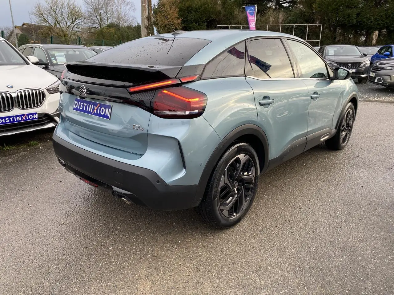 Vue 3/4 arrière droite d'une Citroën C4 bleu Iceland nacré avec jantes alliage 18'' Aeroblade et toit noir.